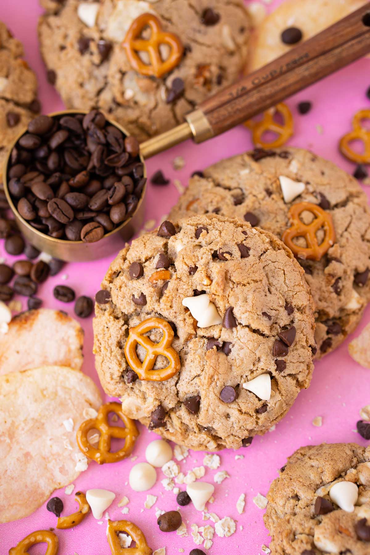 Compost cookies on a pink surface with ingredients around it.