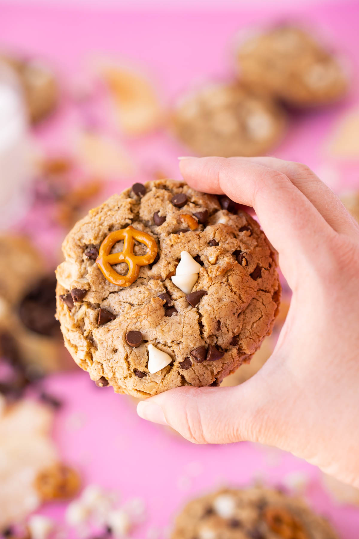 A woman's hand holding a compost cookie to the camera.