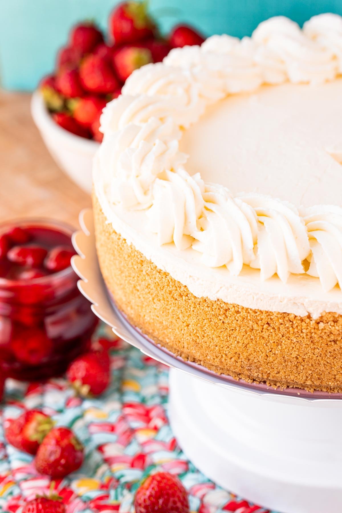 A no bake cheesecake on a white cake stand.