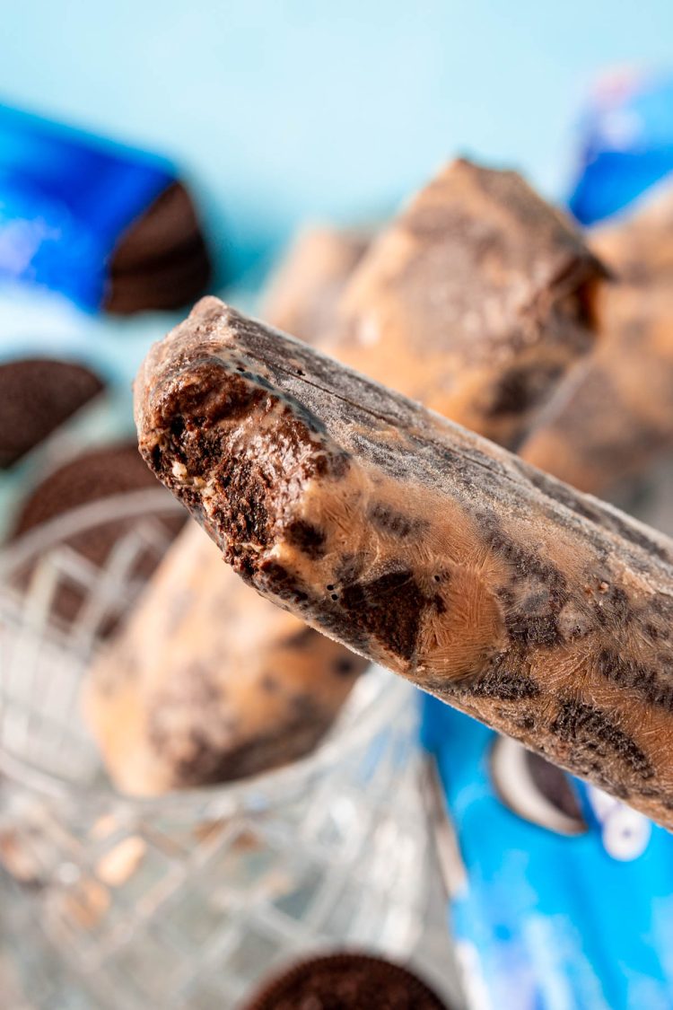 An Oreo popsicle with a bite missing from it.