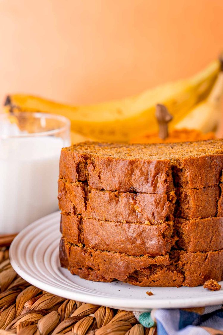 Slices of pumpkin banana bread stacked on a plate.