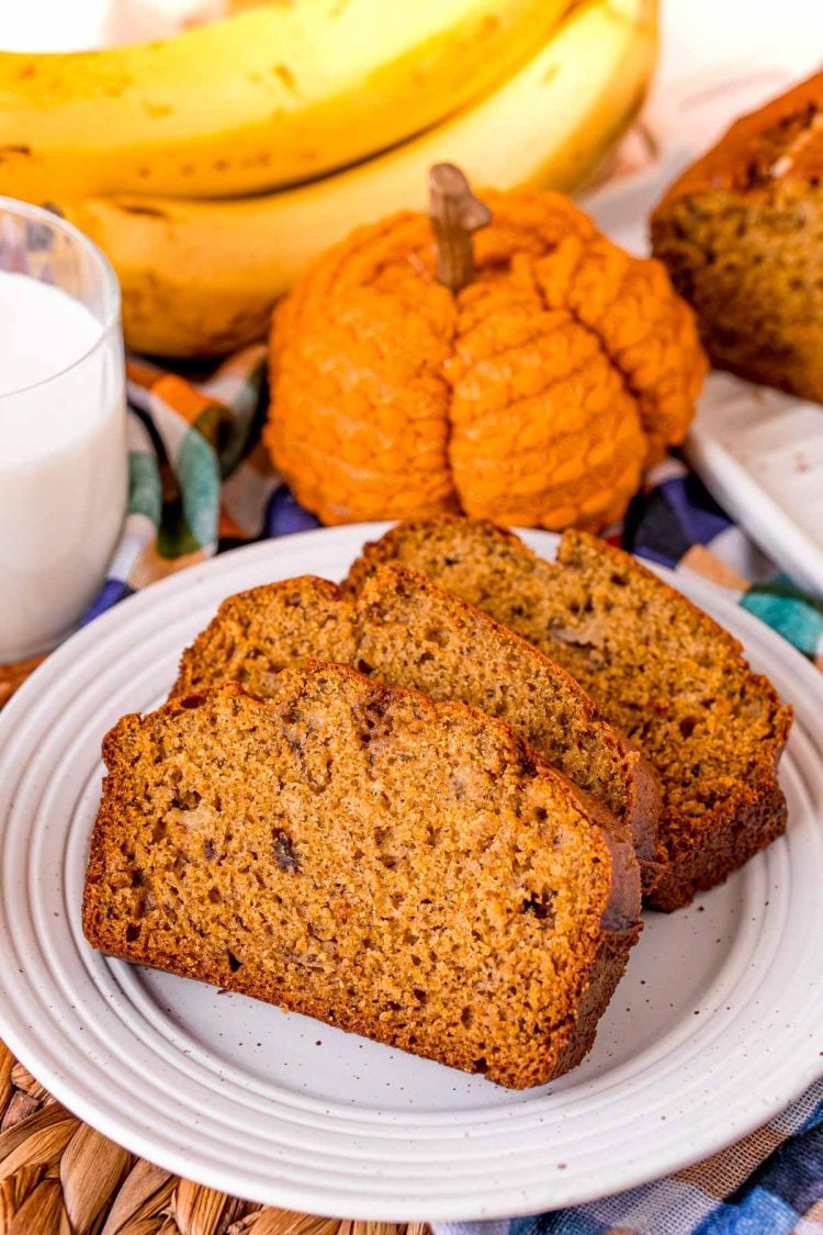 Three slices of pumpkin banana bread on a white plate.