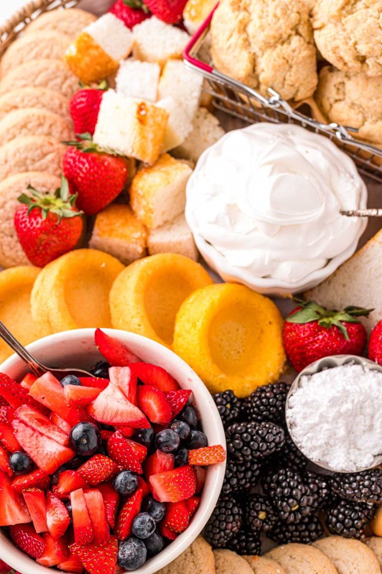 Ingredients to make berry shortcakes on a board.