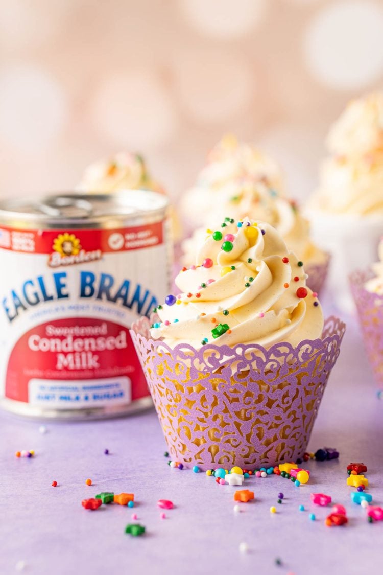 A cupcake topped with Russian buttercream on a purple surface.