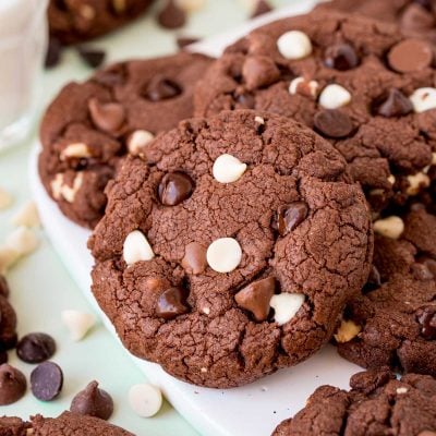 Triple chocolate chip cookies on a white board.