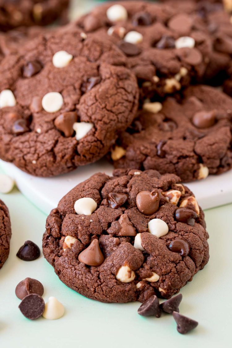 Triple chocolate chip cookies on a white board.