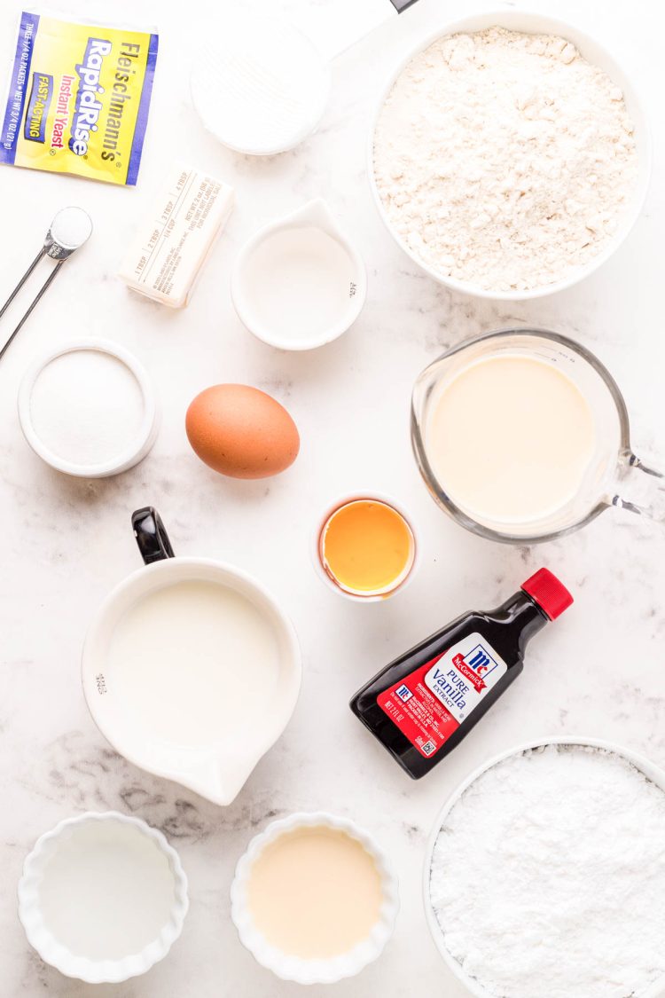 Ingredients to make yeast donuts from scratch on a marble counter.