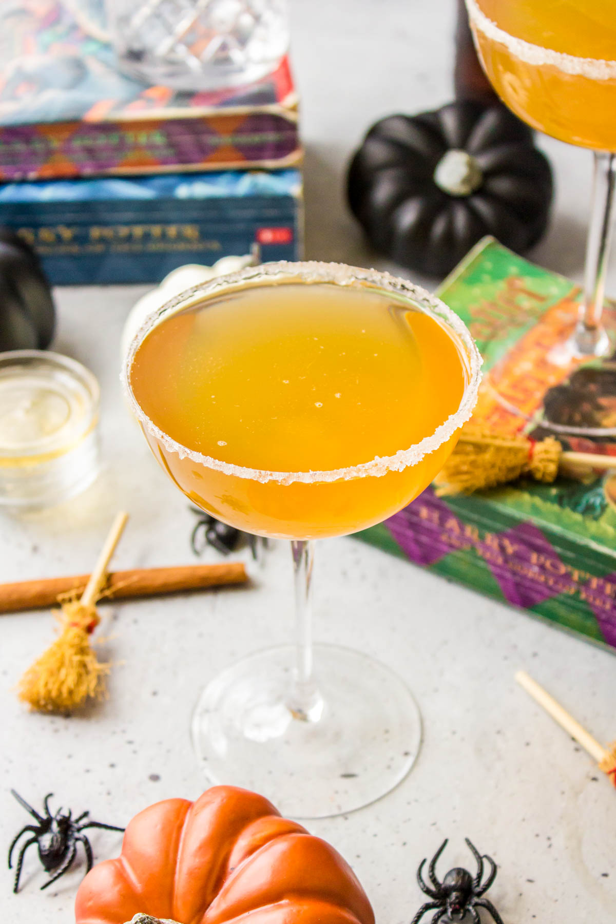 Butterbeer cocktails in coupe glasses with Harry Potter books in the background.