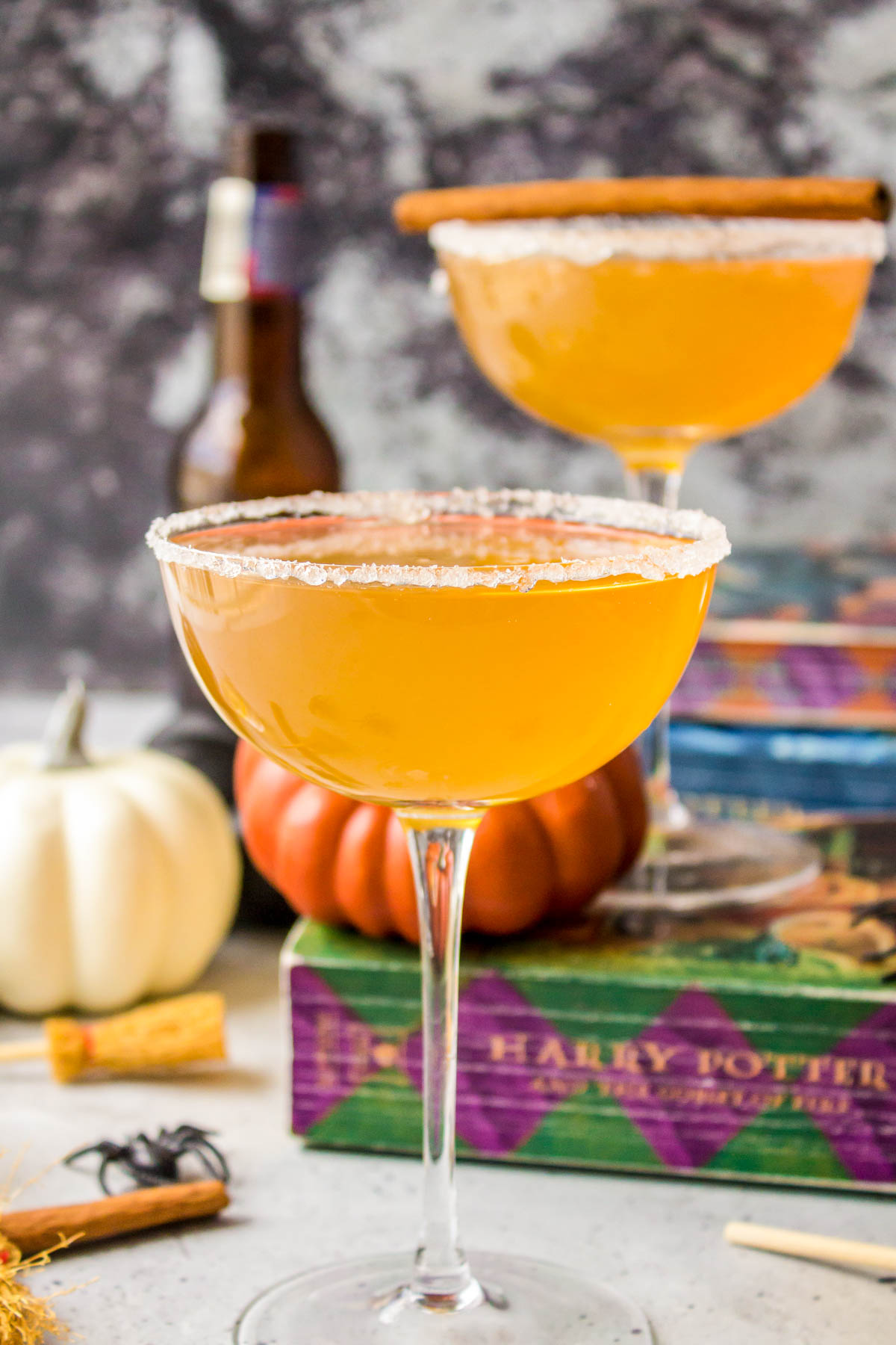 Butterbeer cocktails in coupe glasses with Harry Potter books in the background.