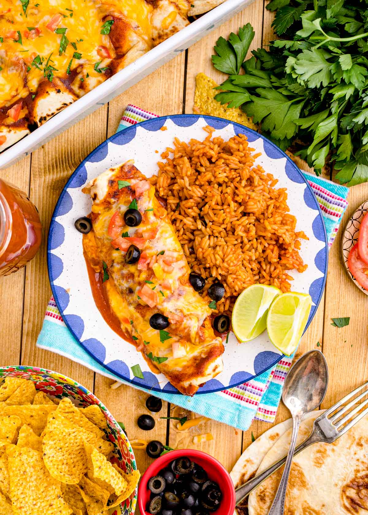 Overhead photo of chicken enchiladas on a plate with rice.