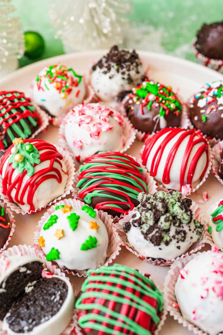 Close up photo of Christmas decorated Oreo balls on a white plate.