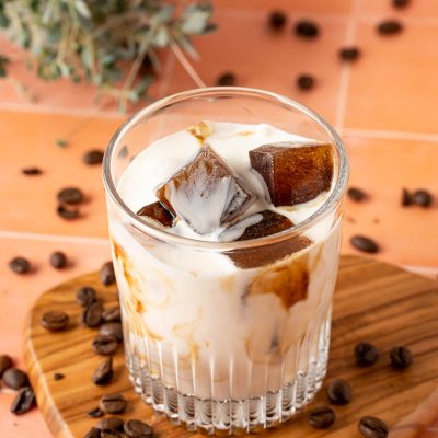 Coffee ice cubes in a glass with milk.