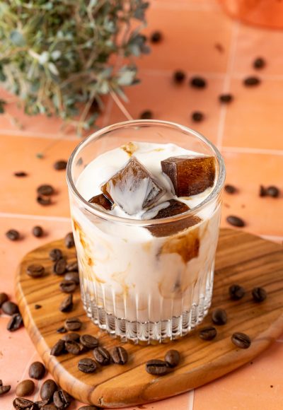 Coffee ice cubes in a glass with milk.