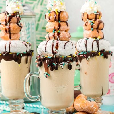 Three coffee milkshakes topped with donuts.