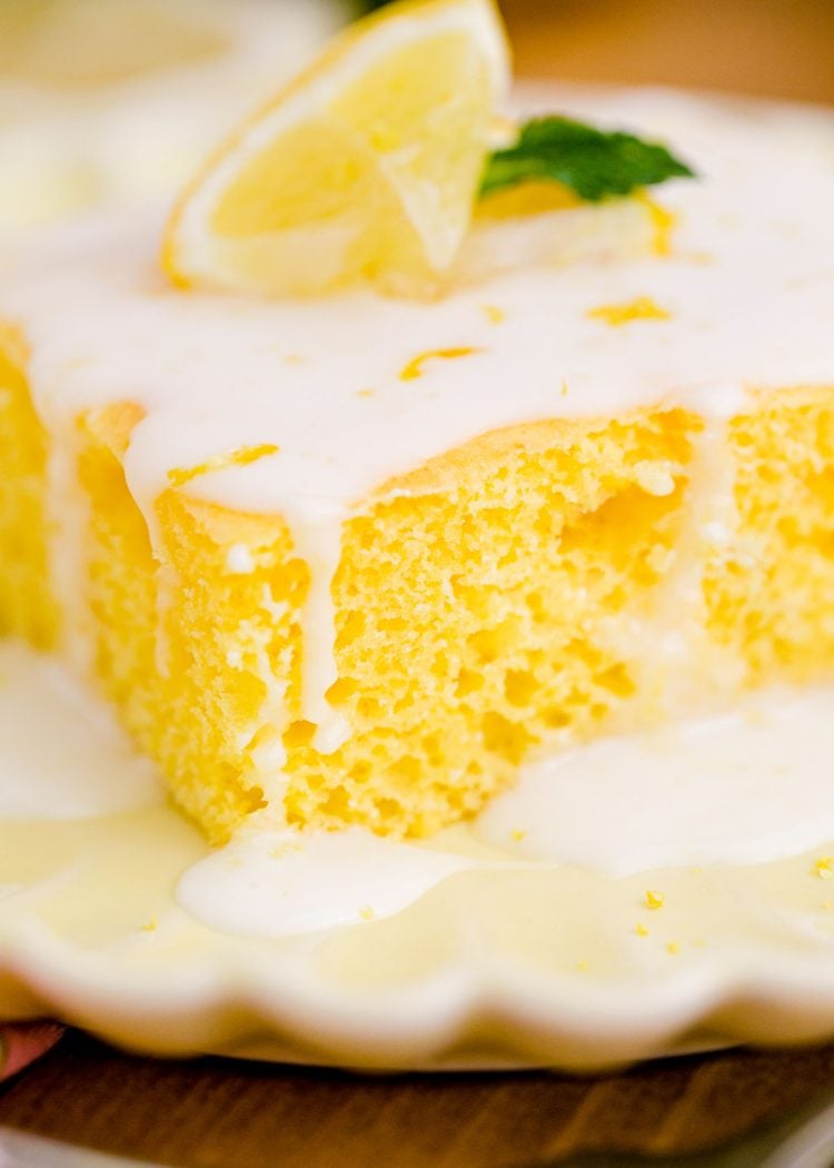 Close up photo of a slice of lemon texas cake on a yellow plate.