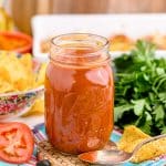 A jar of homemade enchilada sauce on a table.