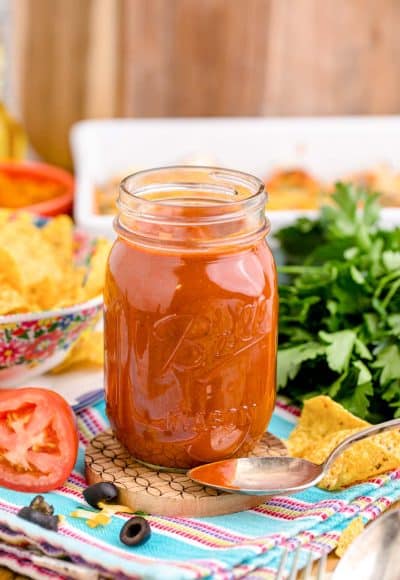 A jar of homemade enchilada sauce on a table.