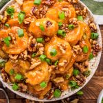 Overhead photo of a bowl of honey walnut shrimp on a wooden table.