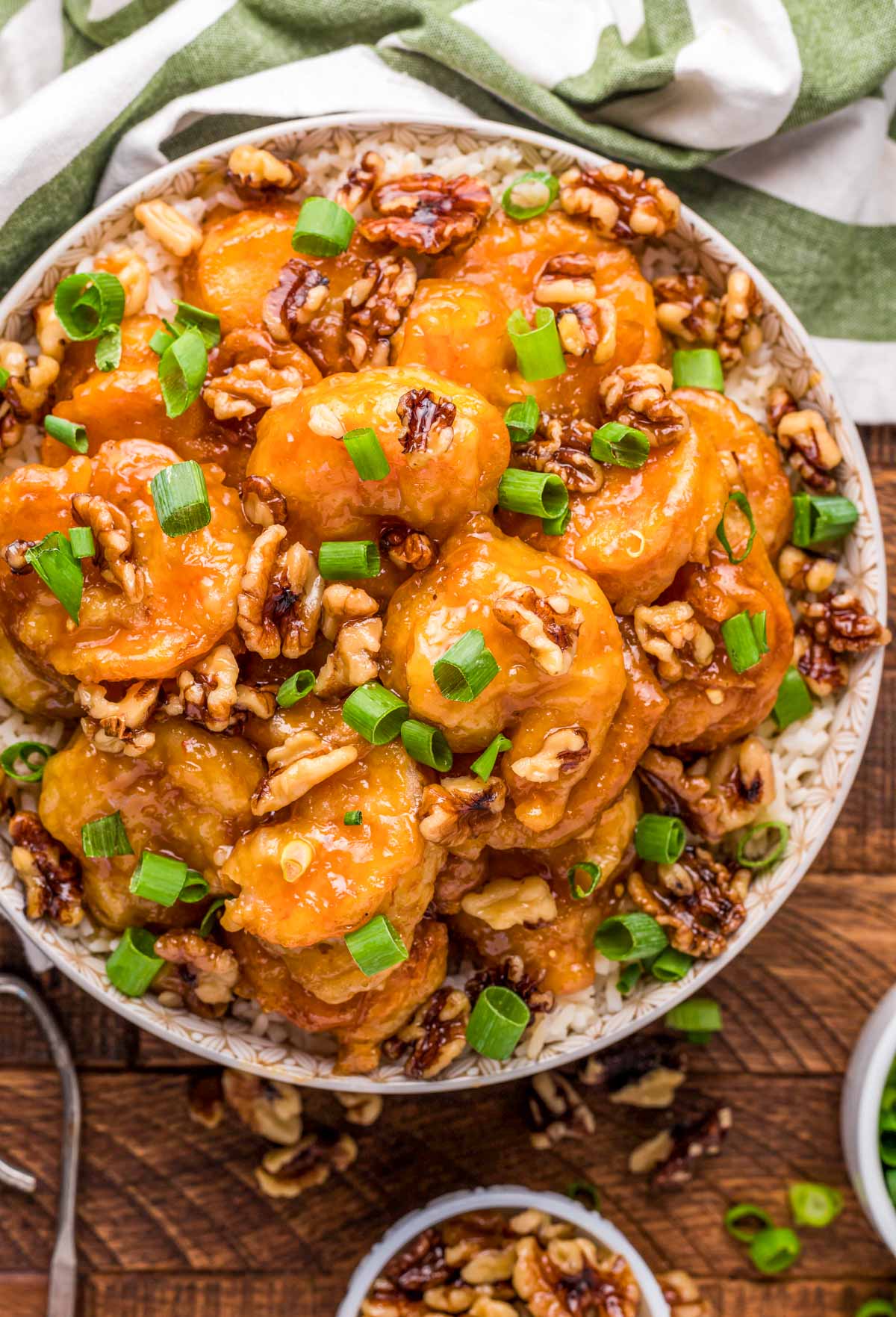 Overhead photo of a bowl of honey walnut shrimp on a wooden table.