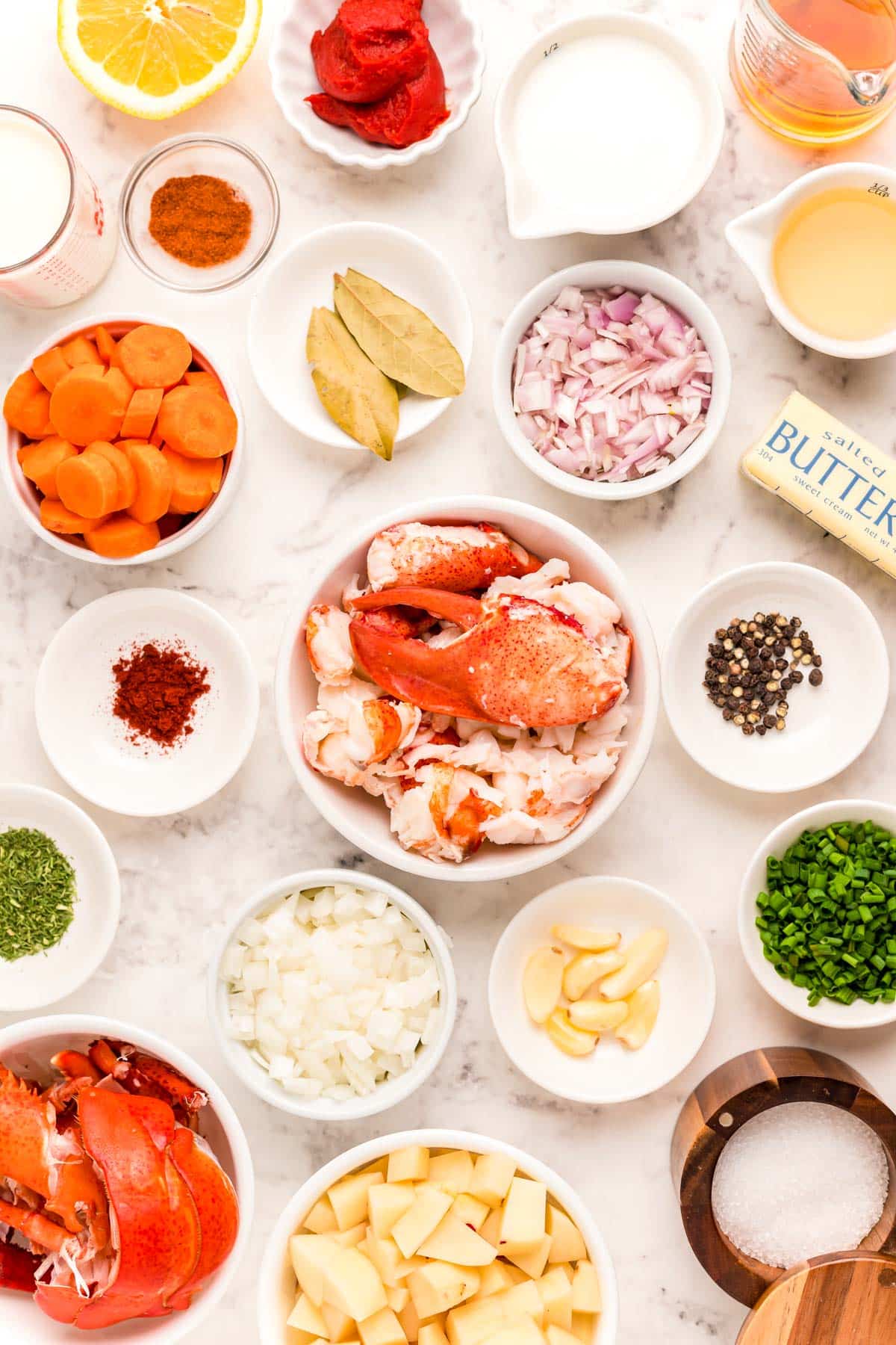 Ingredients to make lobster bisque on a marble table.