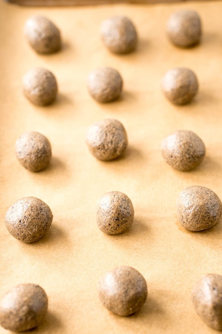 Peanut butter Oreo balls on a piece of parchment paper ready to be dipped in chocolate.