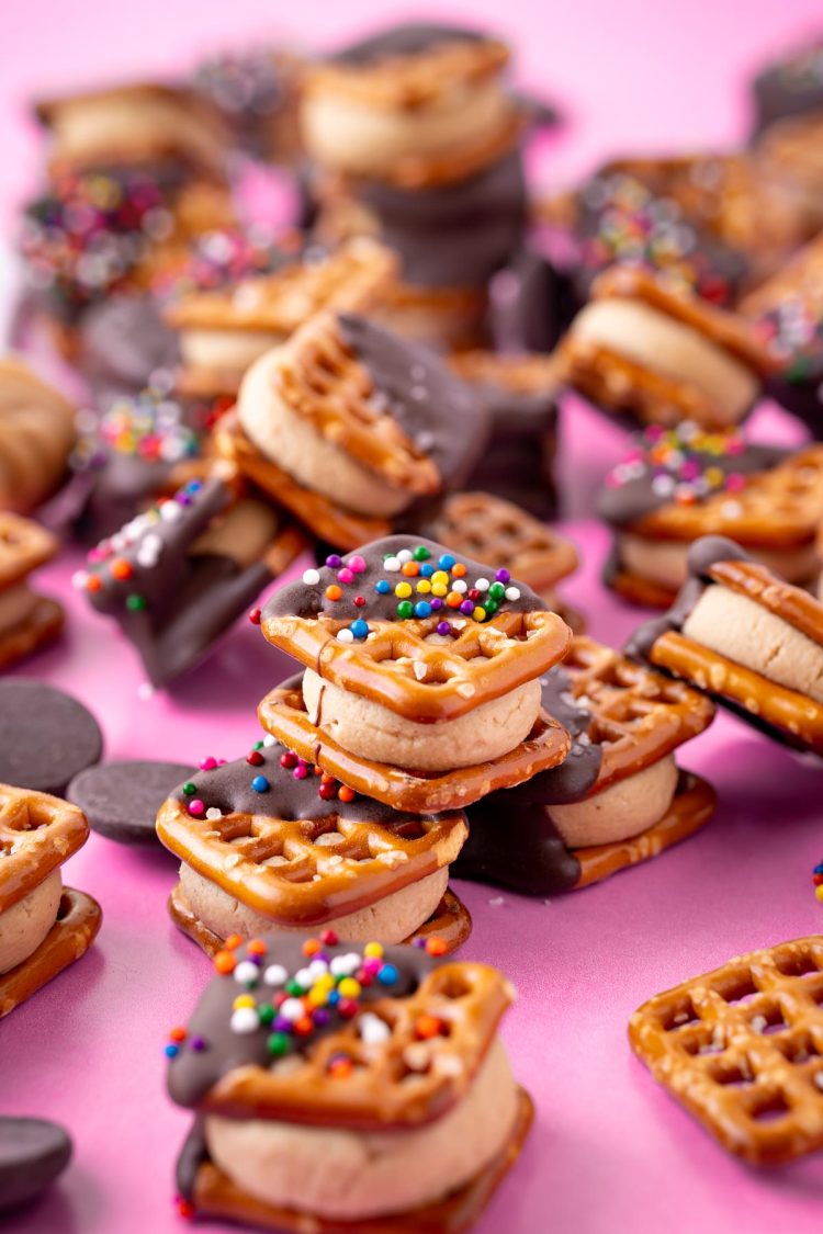 Peanut butter pretzel bites on a pink surface.