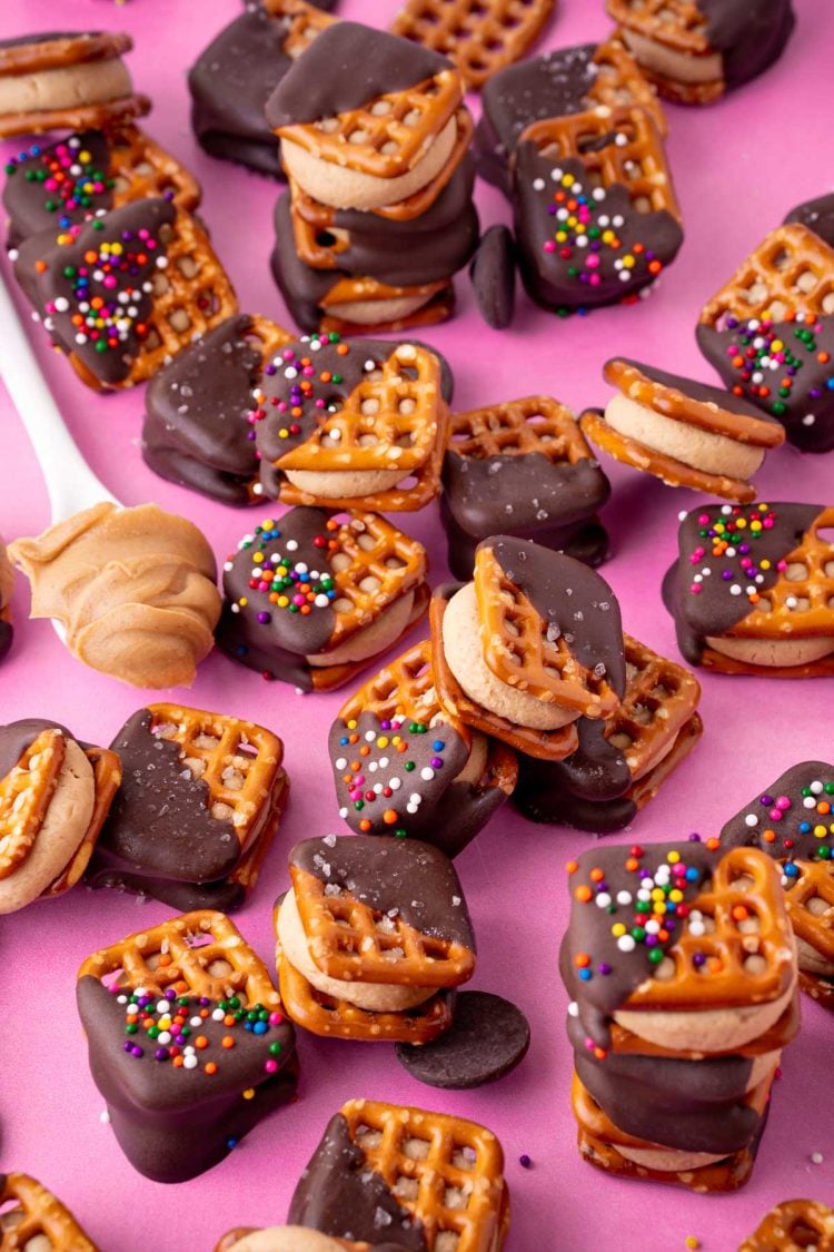 Peanut butter pretzel bites on a pink surface.