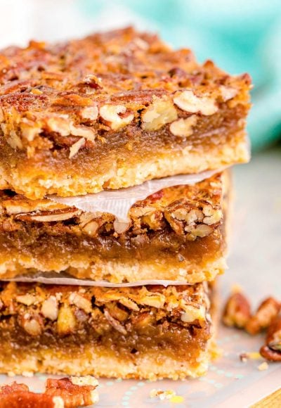 Close up photo of a stack of three pecan pie bars.