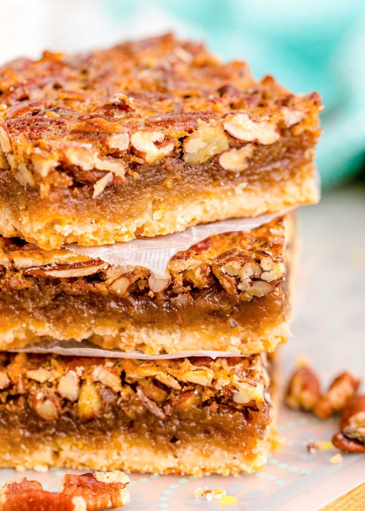 Close up photo of a stack of three pecan pie bars.