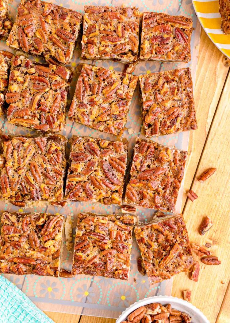 Overhead photo of pecan pie bars sliced on a wooden table.