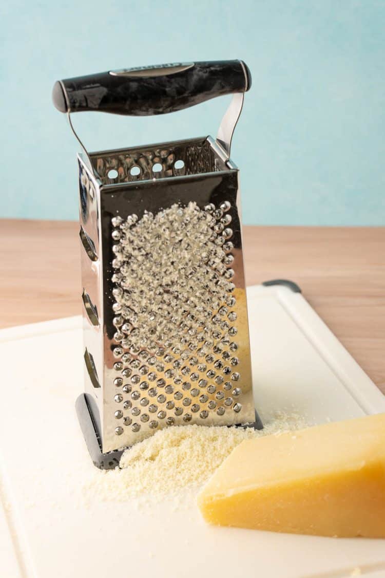Parmesan cheese bring grated into cheese dust.
