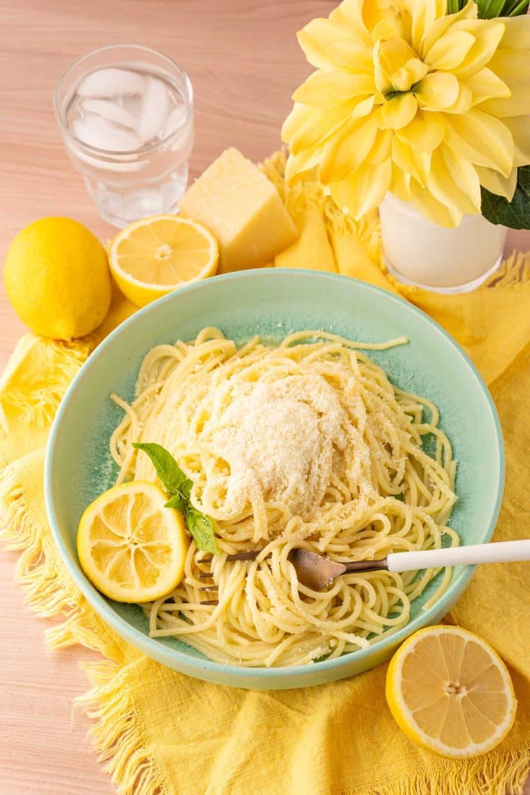 Lemon Butter Pasta (Spaghetti Limone) in a mint green bowl on a yellow cloth napkin.