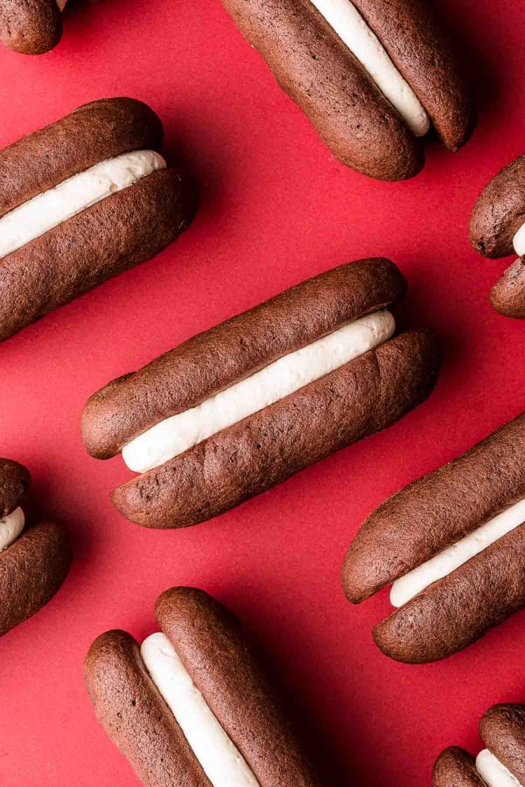 Homemade devil dogs on a red surface.