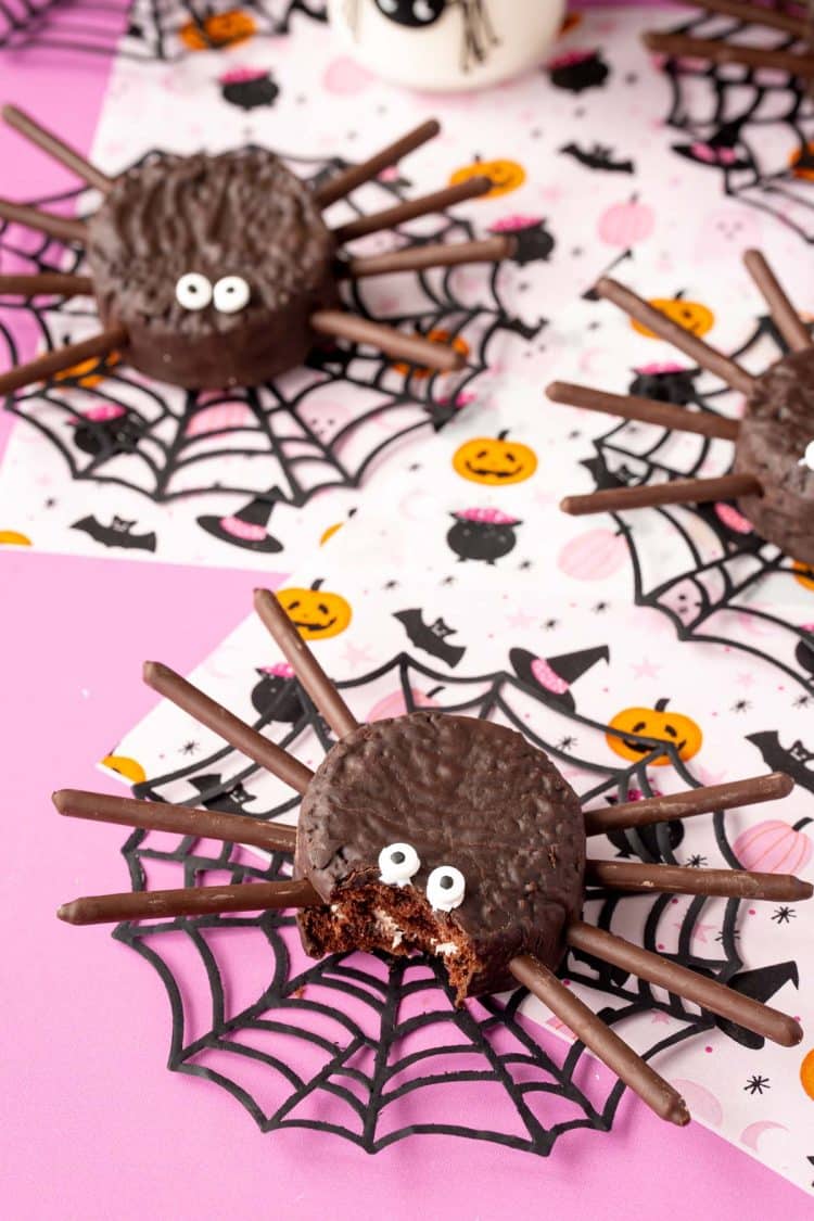Hostess ding dong spider cakes ready for Halloween - one is missing a bite.