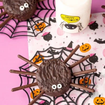 Hostess ding dong spider cakes on a pink Halloween decorated surface.