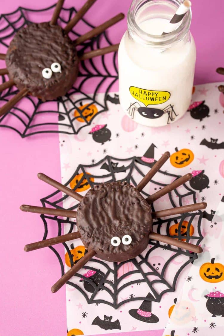 Hostess ding dong spider cakes on a pink Halloween decorated surface.