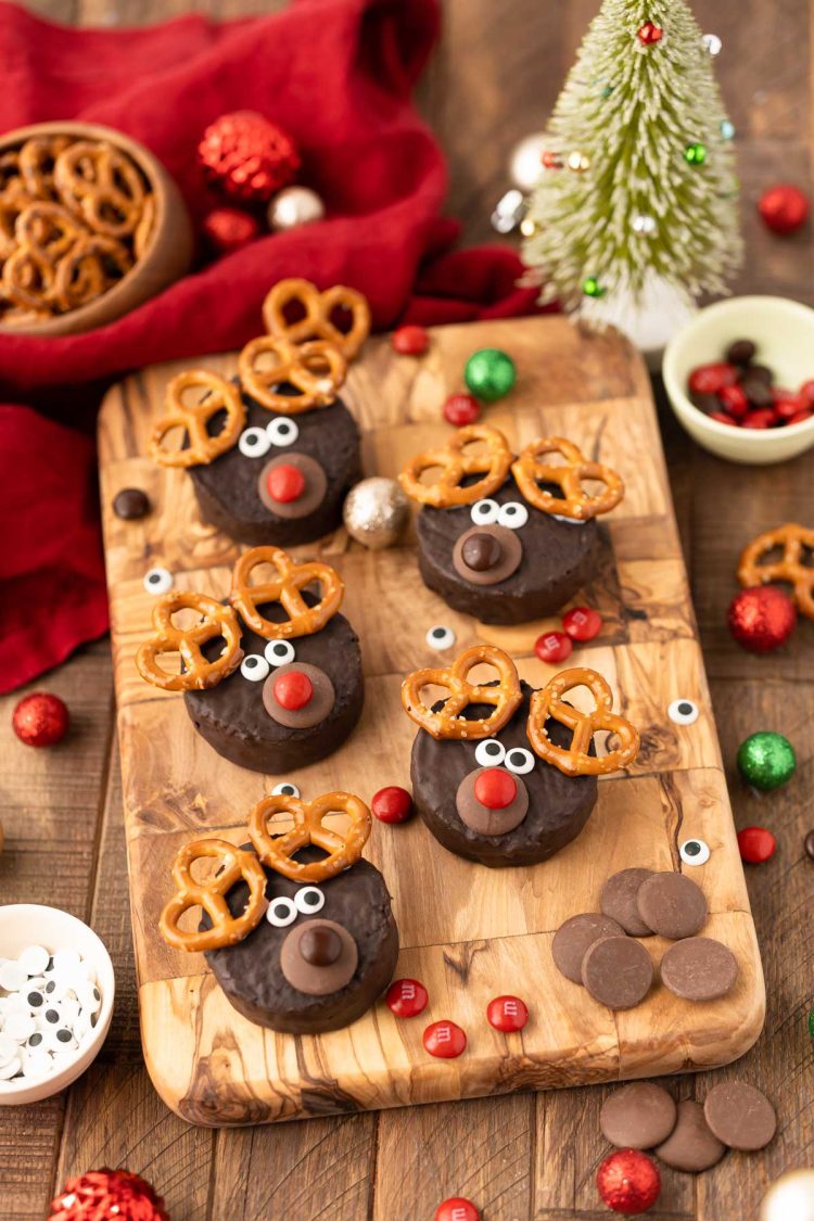 Mini reindeer cakes on a wooden board.