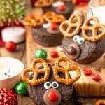 Easy Reindeer Cakes made from ding dongs on a wooden table surrounded by holiday decor.
