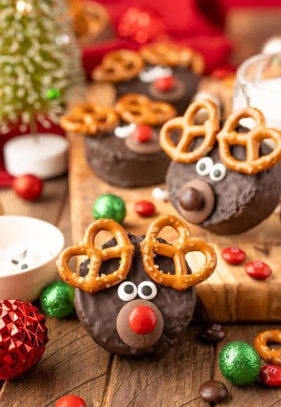 Easy Reindeer Cakes made from ding dongs on a wooden table surrounded by holiday decor.