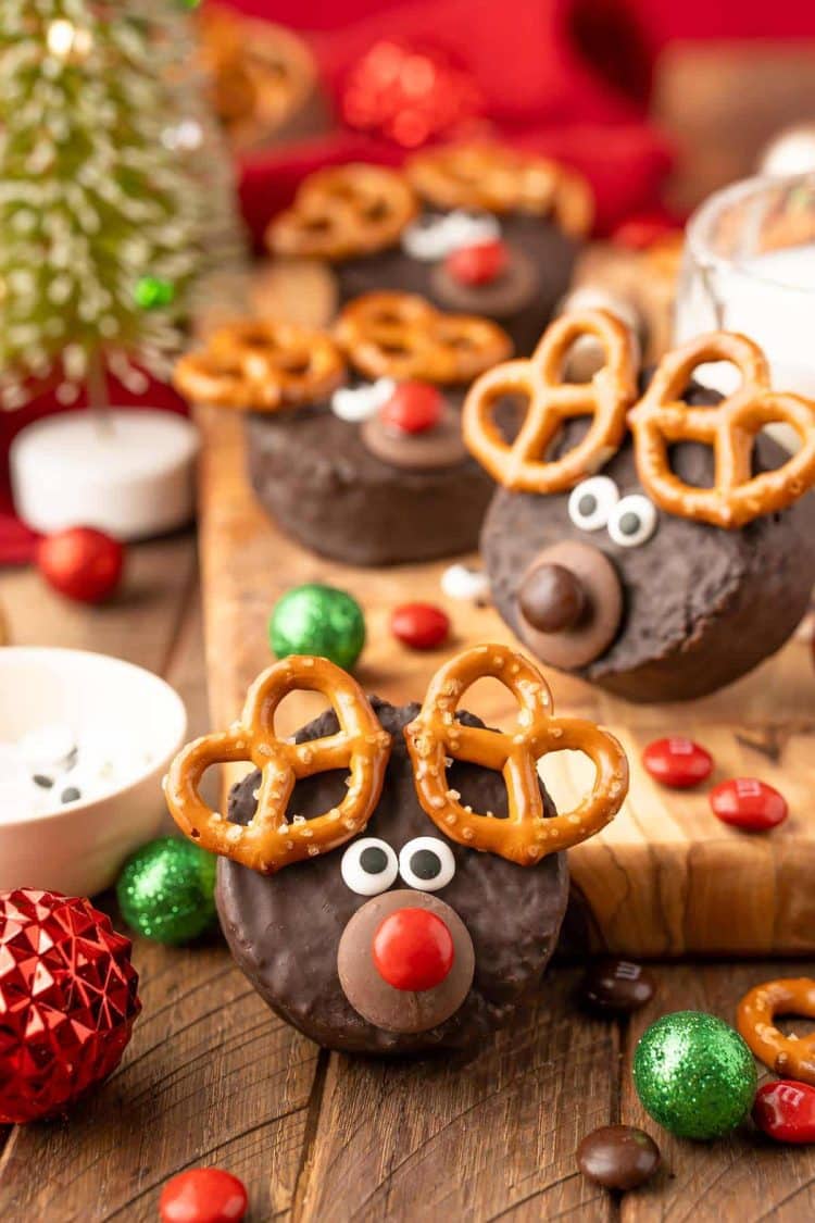 Easy Reindeer Cakes made from ding dongs on a wooden table surrounded by holiday decor.