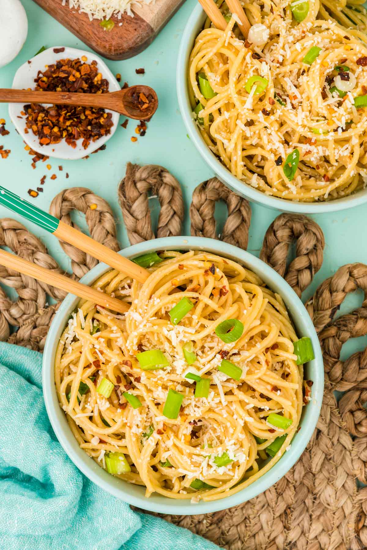 Overhead photo of garlic noodles on a rattan placemat.