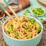 Garlic noodles in a blue bowl on a plate.