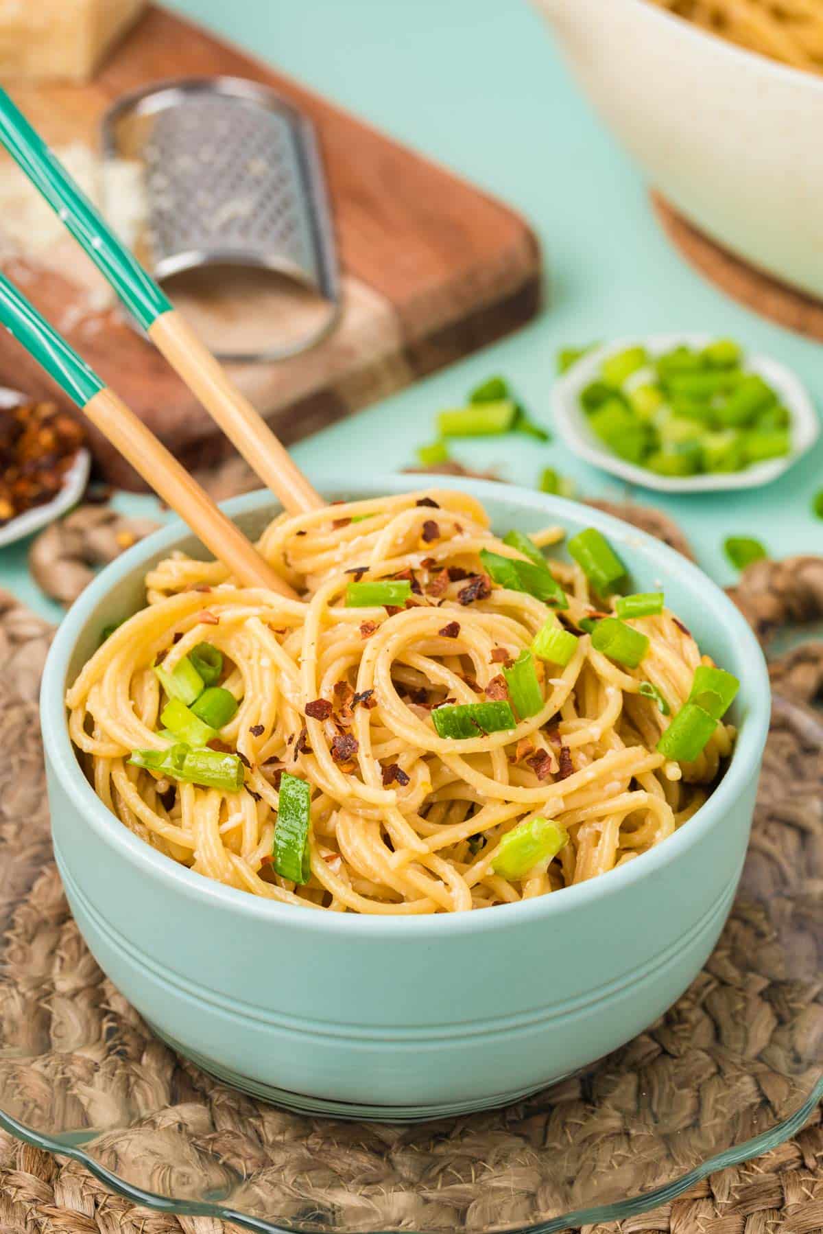 Garlic noodles in a blue bowl on a plate.