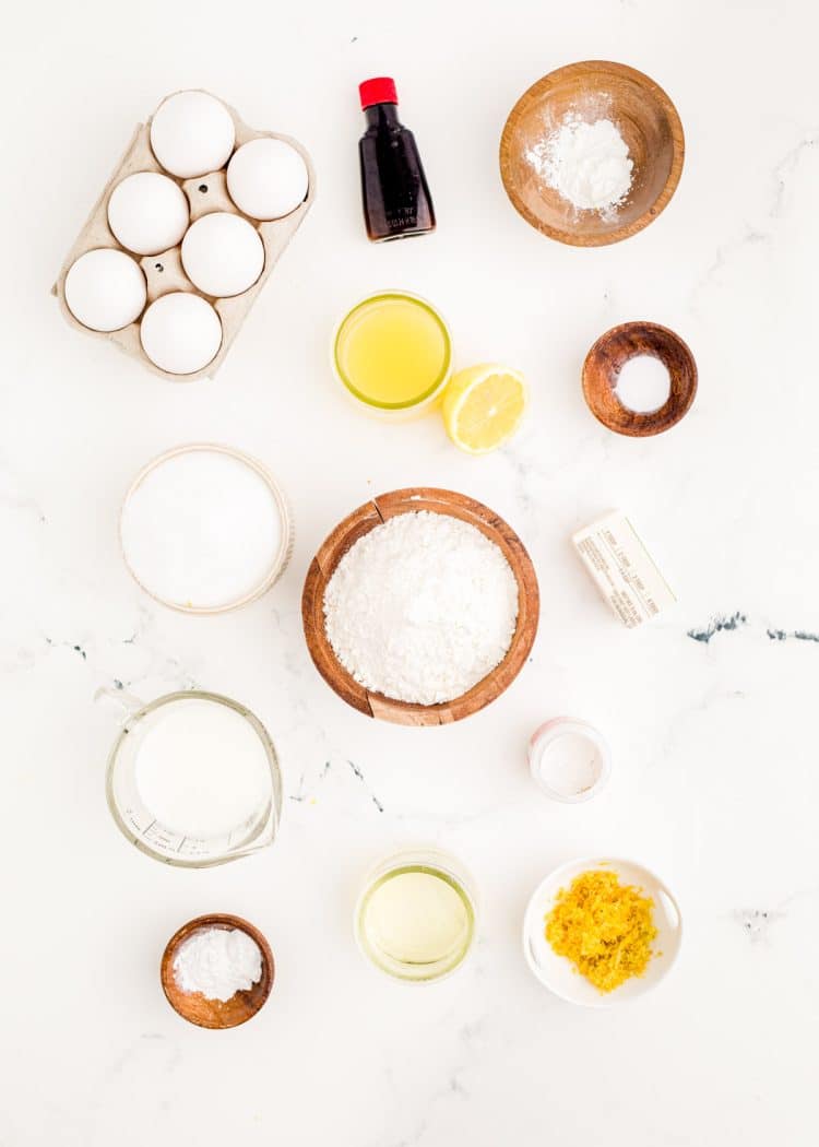 Ingredients to make lemon meringue cupcakes on a marble surface.