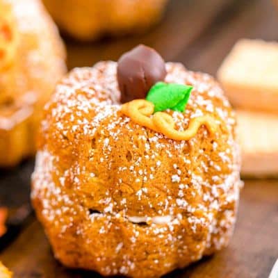 A mini pumpkin bundt cake on a white and mint green plate.