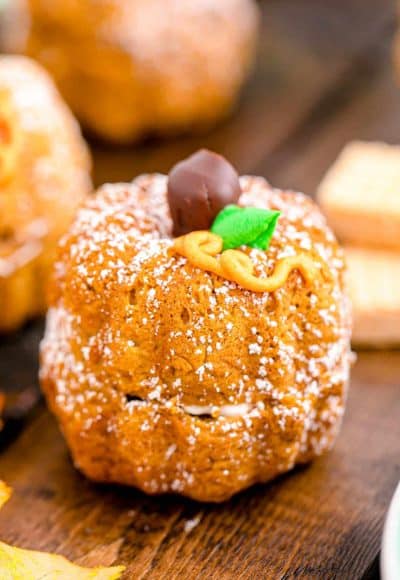 A mini pumpkin bundt cake on a white and mint green plate.