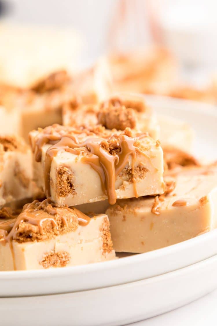 Slices of Biscoff Fudge stacked on a white plate.