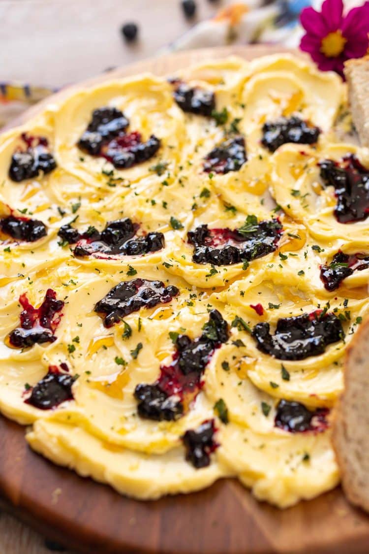 A butter board made with honey, blueberry jam, lemon zest, and basil.