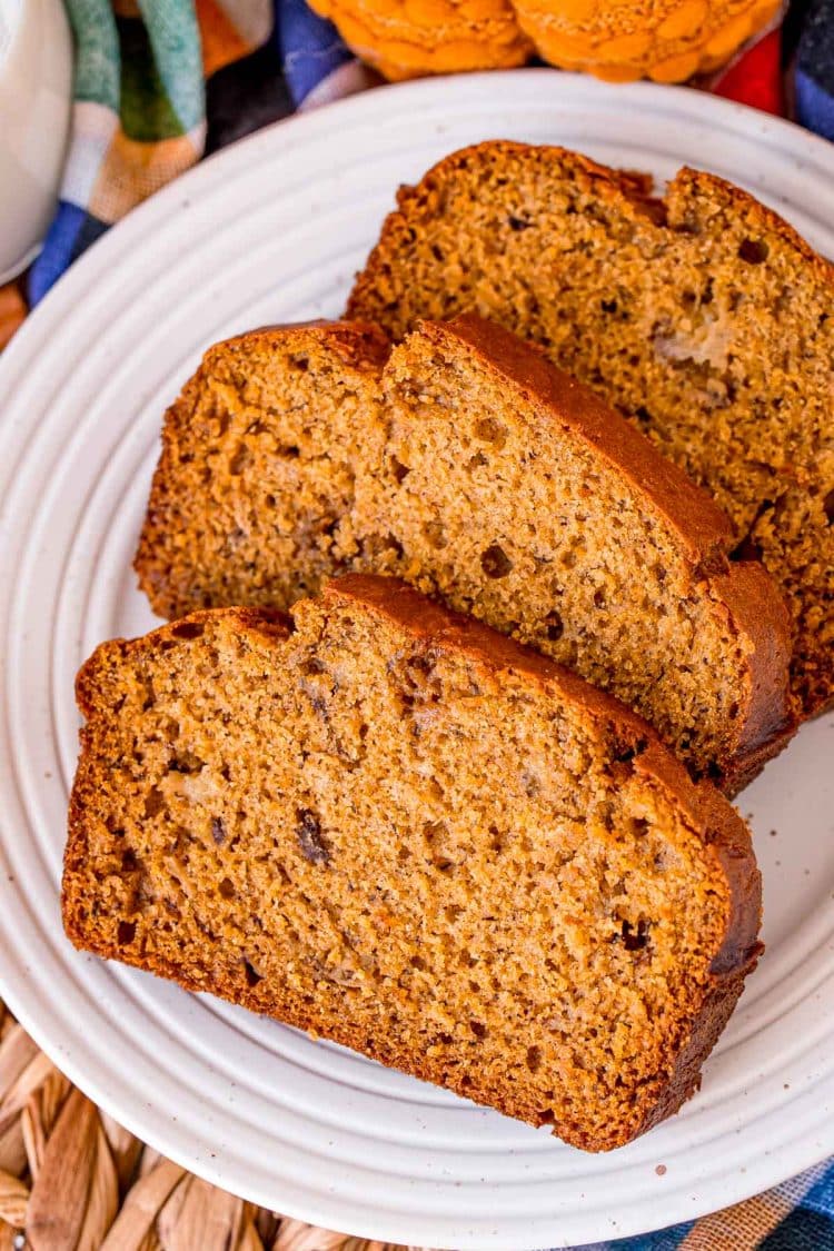 Overhead photo of three slices of pumpkin banana bread on a white plate.