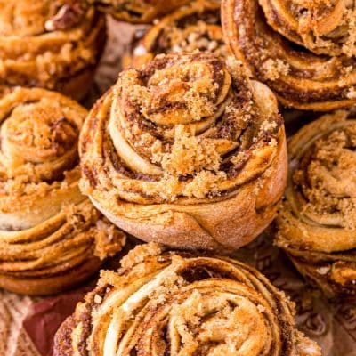 Pumpkin Cinnamon Roll Muffins piled on top of each other.